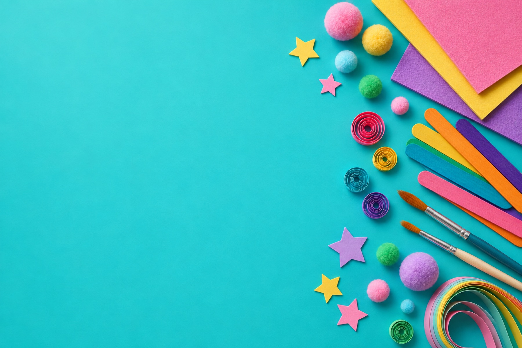 Colourful craft materials arranged on a Tiffany blue background